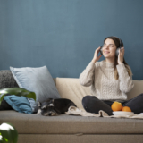 young-woman-using-headphones-sofa